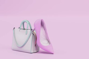 Beyaz bir kadın çantası ve pastel arka planda pembe topuklu bir ayakkabı. 3 Boyutlu Hazırlama.
