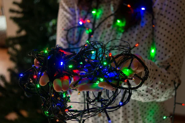 파란색 불빛으로 크리스마스 트리를 장식하는 여성의 클로즈업 — 스톡 사진