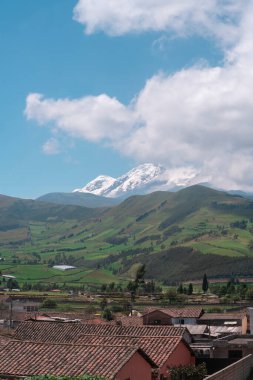 Cayambe ilindeki Olmedo kasabasının panoramik manzarası ve güneşli bir sabah sırasında arka planda Cayambe volkanı - Ekvador