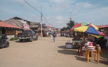 Canoa, Manabi / Ecuador - August 20 2022: People walking along the boardwalk of the town full of shops and merchants on a sunny day