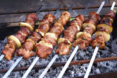 Coocking meat and onions on charcoal on summer day