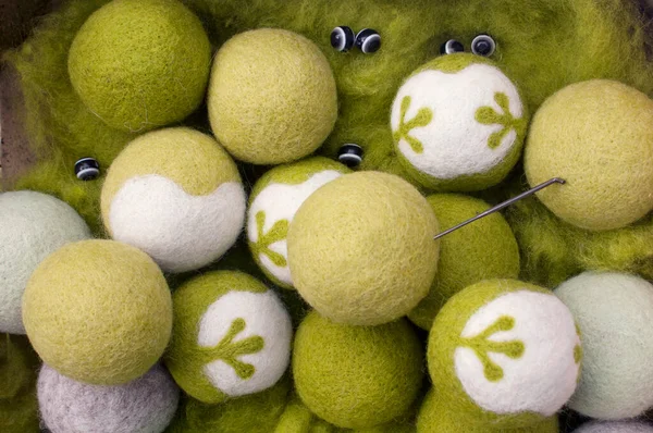Circles of sheep's wool of different shades made using the technique of dry felting with beads and a needle for felting