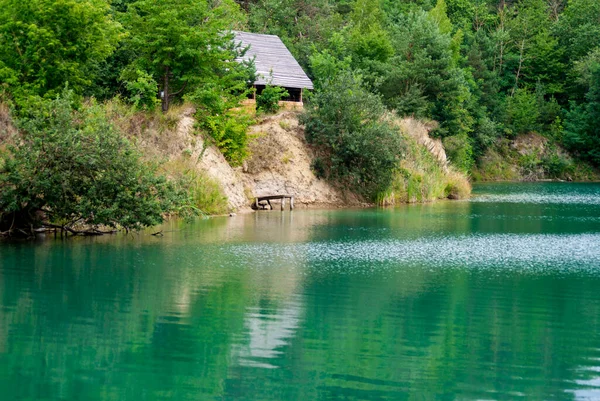 A beautiful Ukrainian lake based on a clay quarry with steep banks and trees around on a summer day