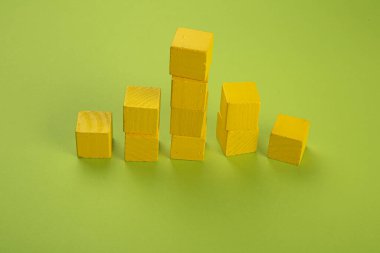 Yellow wooden chips in the form of a tower on a light green background