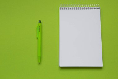 Blank notepad with green pencil on light green background