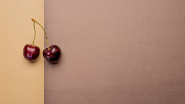 Cherries top view on color background