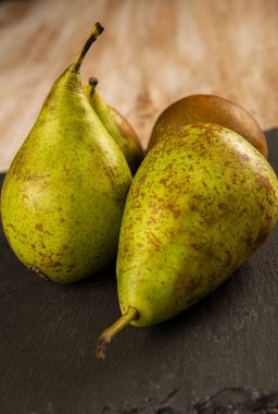 Organically grown pears on black slate and old wood