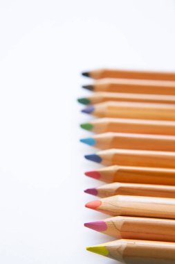 wooden colored pencils on blank page of a notebook