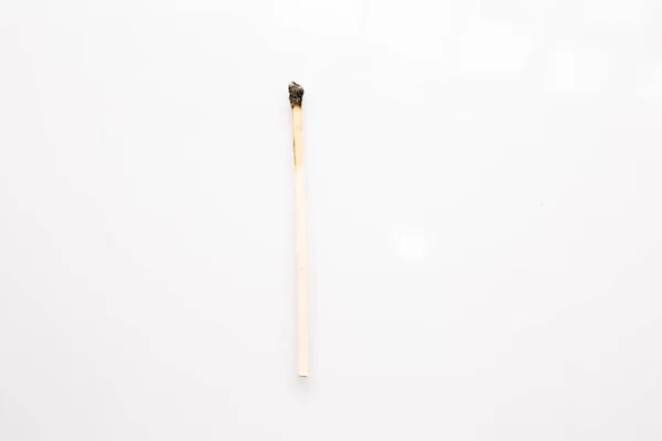 Small burnt wooden match on white background