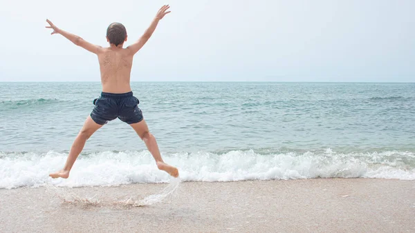 Boy Jumping Joy Looking Beach 图库图片