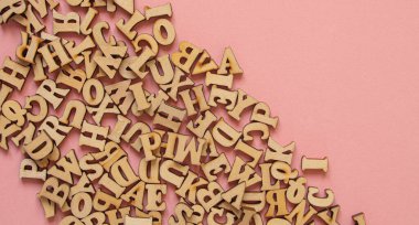 Messy wooden letters on pink background