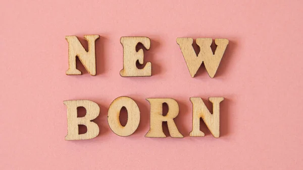 Слово New Born Написано Английском Языке Деревянными Буквами Розовом Фоне — стоковое фото