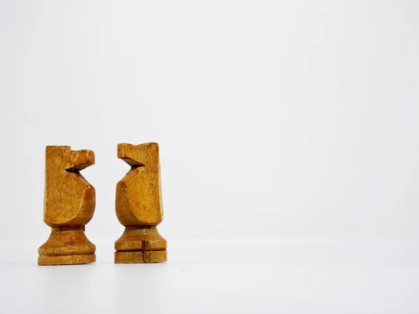 the horse character in this chess game are made in the traditional way, using coconut wood and colored in brown