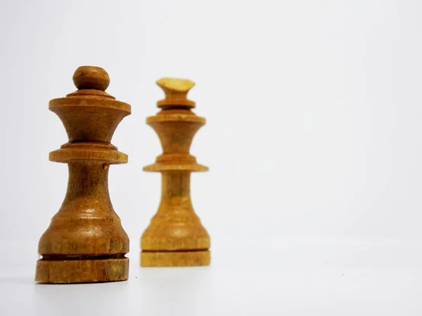 the king and queen character in this chess game are made in the traditional way, using coconut wood and colored in brown