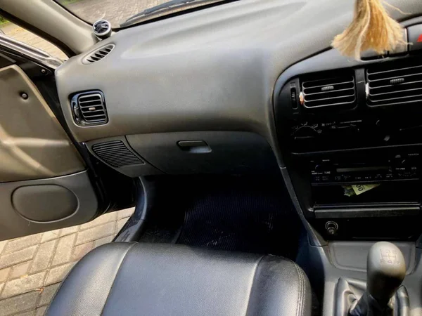 the interior of an old car that is kept clean because it is always routinely maintained by the owner