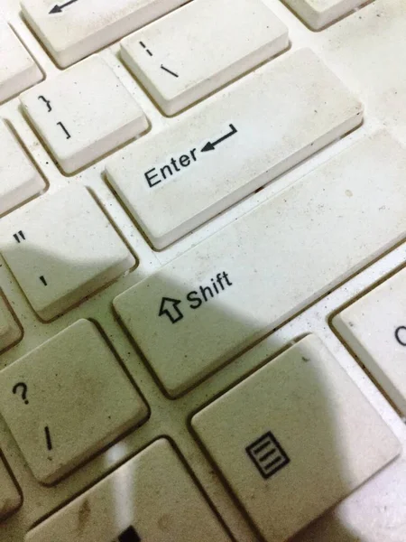 a white keyboard that looks dirty due to hand stains and is rarely cleaned by the owner