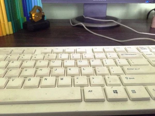 a white keyboard that looks dirty due to hand stains and is rarely cleaned by the owner