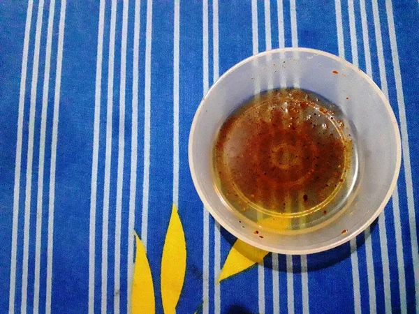 massage oil in a small bowl visible on the mattress with a unique patterned blue sheet