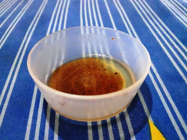 massage oil in a small bowl visible on the mattress with a unique patterned blue sheet