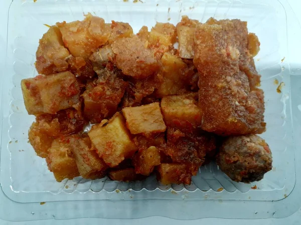 a small box of fried chili sauce stuffed with potatoes, meatballs, beef skin with delicious red spices for the lunch menu