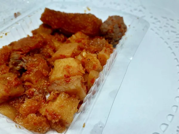 a small box of fried chili sauce stuffed with potatoes, meatballs, beef skin with delicious red spices for the lunch menu