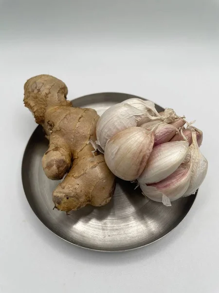 fresh garlic and ginger, on white background. The combination of garlic and ginger are and amazing duo. They bring out a rich depth of flavor and work miracles with many dishes.