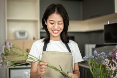 Weekend with her hobbies, Asian woman arranges a bouquet of flowers to decorate her home and beautify, Artificial flower arrangement, living room decoration ideas, Flowers bunch, Arts and crafts.