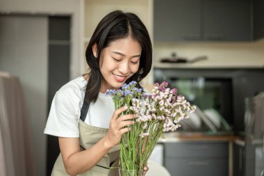 Weekend with her hobbies, Asian woman arranges a bouquet of flowers to decorate her home and beautify, Artificial flower arrangement, living room decoration ideas, Flowers bunch, Arts and crafts.