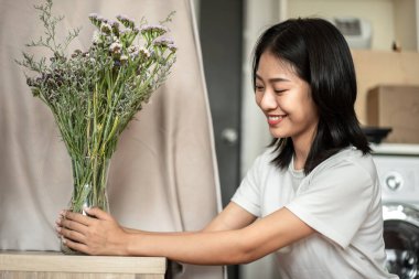 Weekend with her hobbies, Asian woman arranges a bouquet of flowers to decorate her home and beautify, Artificial flower arrangement, living room decoration ideas, Flowers bunch, Arts and crafts.