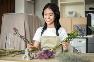 Weekend with her hobbies, Asian woman arranges a bouquet of flowers to decorate her home and beautify, Artificial flower arrangement, living room decoration ideas, Flowers bunch, Arts and crafts.
