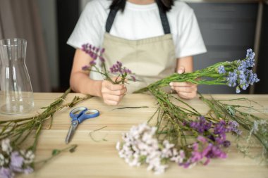 Weekend with her hobbies, Asian woman arranges a bouquet of flowers to decorate her home and beautify, Artificial flower arrangement, living room decoration ideas, Flowers bunch, Arts and crafts.