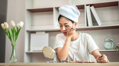 Half Japanese woman putting on makeup and hair to prepare for work in the morning, Facial care and cosmetics, Make up mirror,  Take a shower and put on make-up and get dressed and ready to go to work.