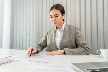 Asian business women are analyzing company sales statistical graphs to develop them furthe