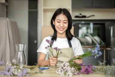 Weekend with her hobbies, Asian woman arranges a bouquet of flowers to decorate her home and beautify, Artificial flower arrangement, living room decoration ideas, Flowers bunch, Arts and crafts.