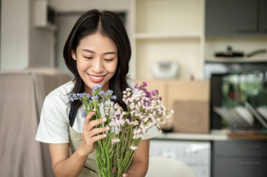 Weekend with her hobbies, Asian woman arranges a bouquet of flowers to decorate her home and beautify, Artificial flower arrangement, living room decoration ideas, Flowers bunch, Arts and crafts.