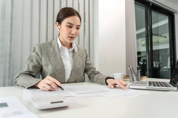 Asian business women are analyzing company sales statistical graphs to develop them furthe