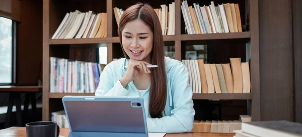 Female Student Using Tablet Homework Classmates While Reading Data Library — Stock fotografie