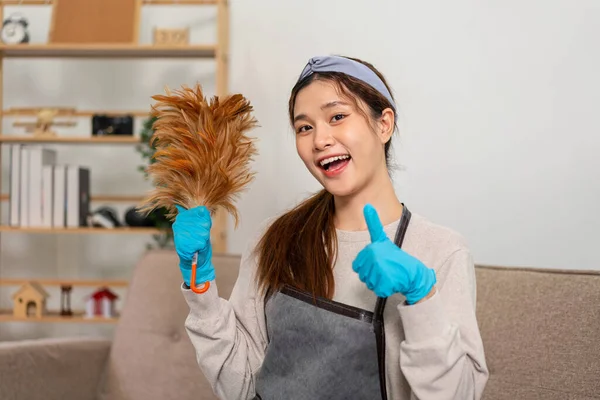 Housekeeper Wearing Protective Gloves Holding Feather Duster Showing Happy Thumbs — Foto Stock