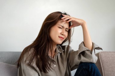 Kanepede oturan ve alnına dokunan kadın çalışanın çok çalıştıktan sonra projede sorunları olduğu için stresli ve hayal kırıklığına uğramış..