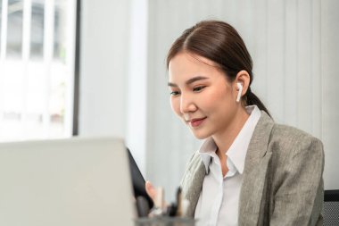 Professional marketing leader uses in-depth analytics tablet to advance the organizational structure, Using a laptop for telecommunication work, Works in a modern office.