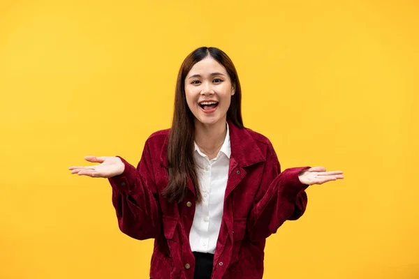 若いですアジアの女性身に着けています赤いジャケットと大きな笑顔ながら両手を開きますプレゼンテーションと広告何かが黄色の背景に隔離 — ストック写真