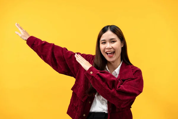 黄色の背景の上で孤立した仕事をした後 若いアジアの女性は赤いジャケットを着て 喜びのために叫んで手を上げる — ストック写真
