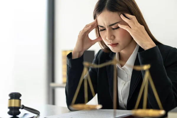 İş kadını avukat kadın, hukuk bürosunda çalışırken dava ve iş sözleşmesinin detaylarını okuduktan sonra stresli ve dokunaklı bir şekilde baş ağrısı çekiyor..