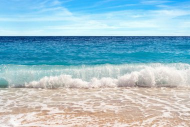 Close up photo of Kaputa beach in Antalya with waves and bubbles.