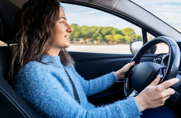 Young woman driving car on the road. Driver licence and driving safety concept.