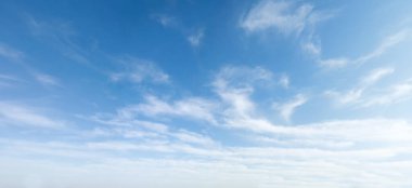Wide angle photo of sunny and windy weather sky with blue tones. Summer or spring sky with cloudscape.