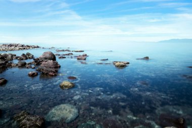 Long exposure photo of sea, rocks and sunset. Concept of relax, calm, tranquil and inner peace.