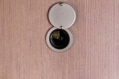 peep hole lens on wooden texture.