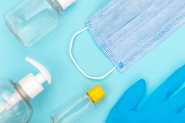 Used coronavirus materials lays on blue isolated background. Waste management and medical pollution concept.