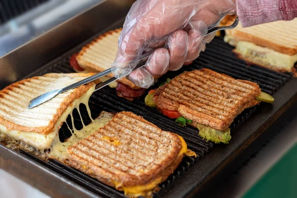Toasted sandwiches with melting cheese on toaster or grill.